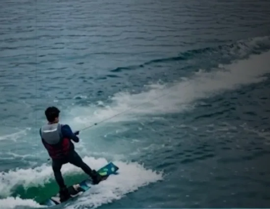 Persona haciendo wakeboard, remolcada sobre el agua