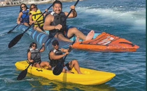 Grupo de amigos en kayaks de colores en el mar
