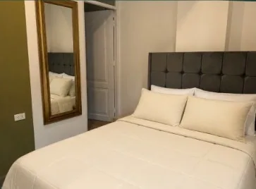 Dormitorio del Deluxe Apartment con cabecera acolchada y espejo