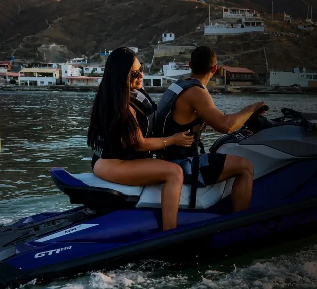 Pareja paseando en moto acuática frente a la costa
