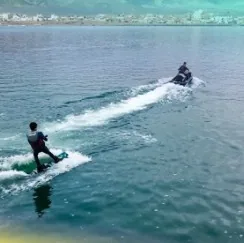 Vista aérea de una persona haciendo wakeboard detrás de una moto acuática